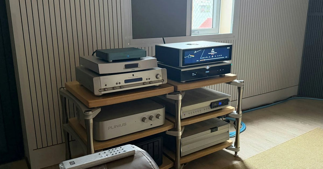Appareils hi-fi empilés sur un meuble audio en bois