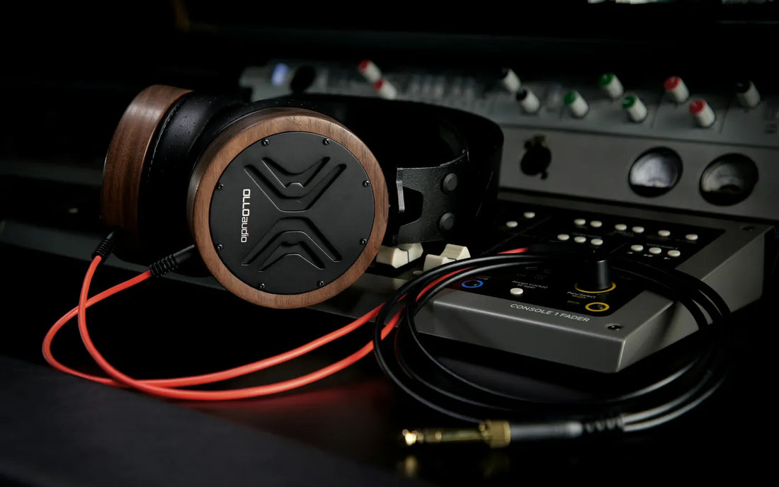 Casque studio posé sur une console de mixage, câble rouge branché